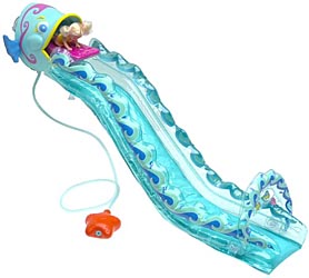 Kelly in a pink raft at the top of a blue fish-shaped waterslide, with a hose leading to an orange pump.